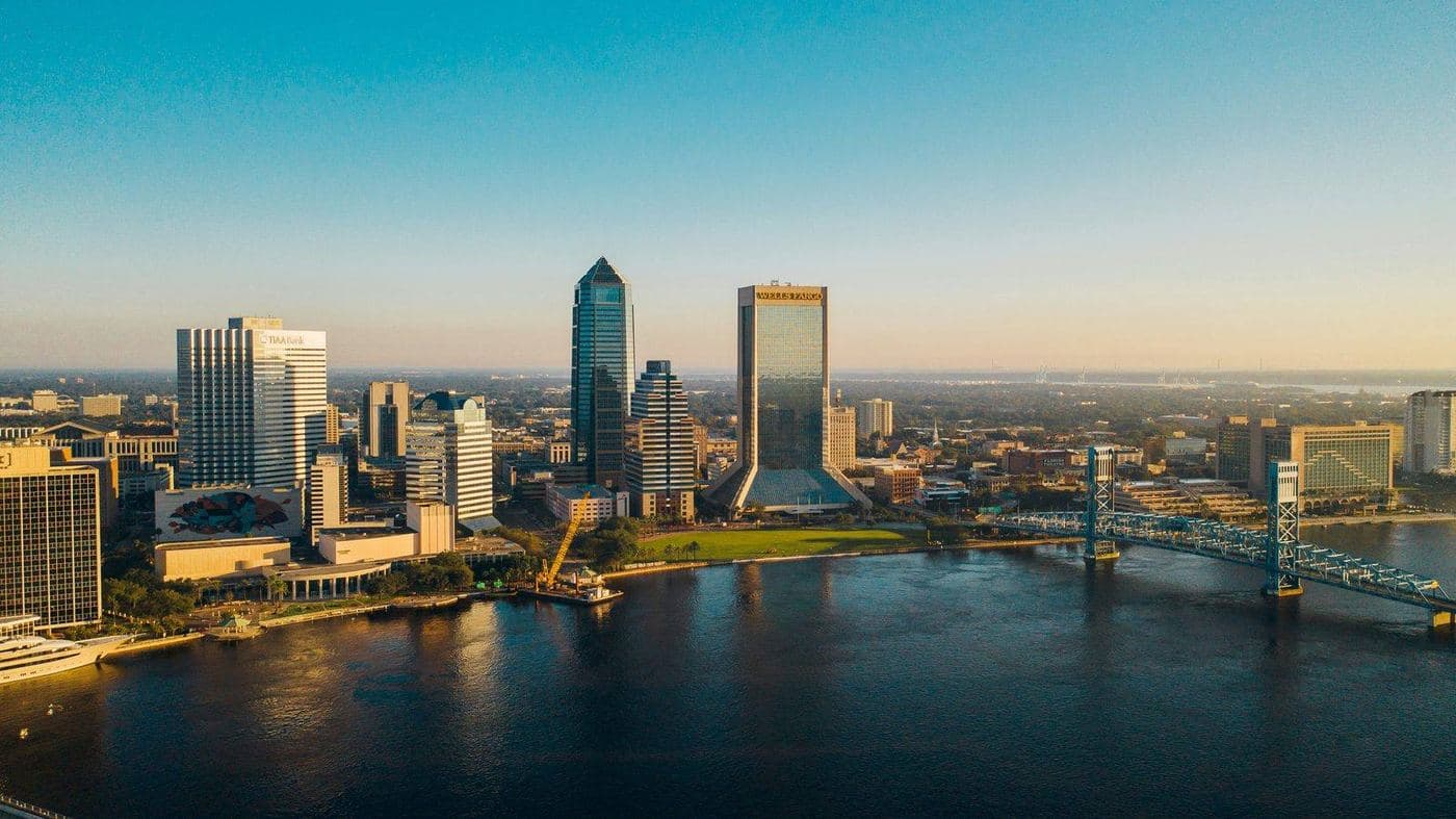 Aerial view of downtown Jacksonville, Florida at sunset, with the St. Johns River and Main Street Bridge